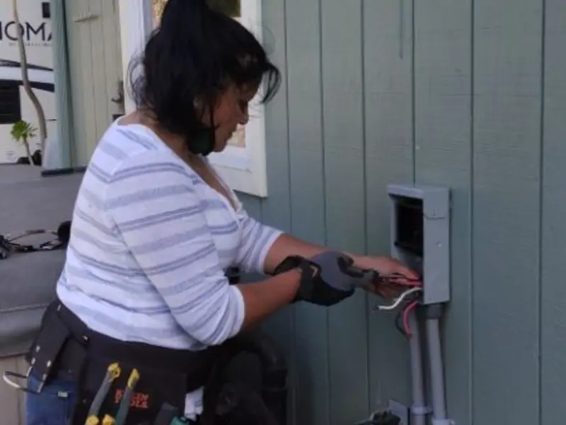 Licensed electrician wiring an exterior subpanel in Hays